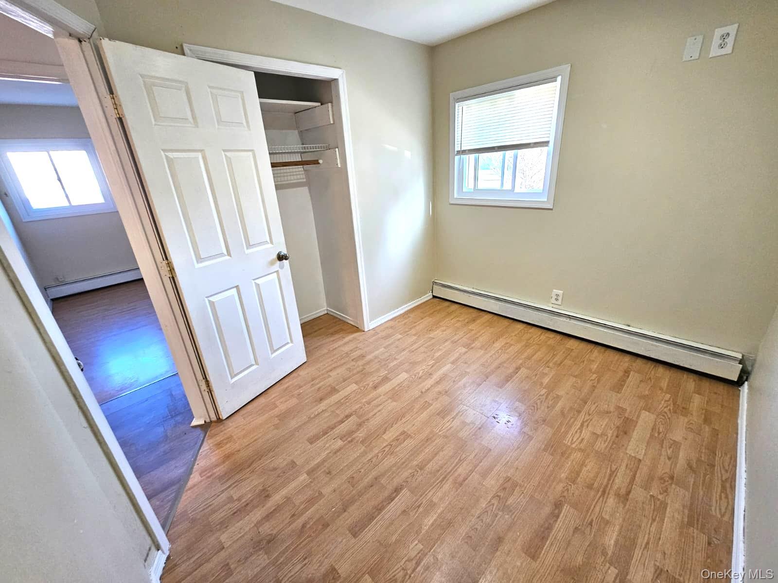 56 Applegate Drive Central Islip, NY 11722 - Photo 9 of 33 a view of an empty room with wooden floor and a window