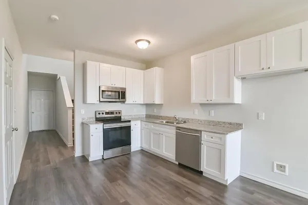 a kitchen with granite countertop white cabinets and stainless steel appliances