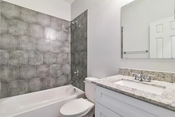 a bathroom with a granite countertop sink toilet and bathtub