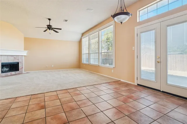 an empty room with windows and fireplace