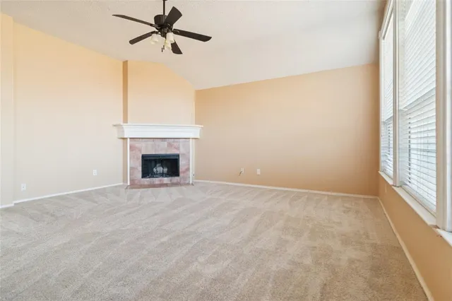 a view of an empty room with a fireplace and a window