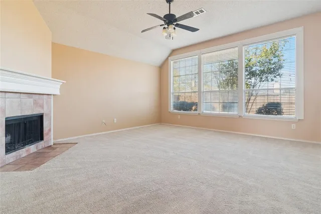 a view of an empty room with a fireplace and a window