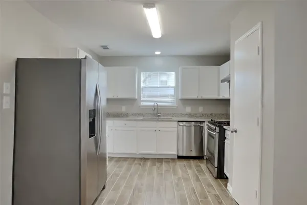 a kitchen with a sink a refrigerator and window