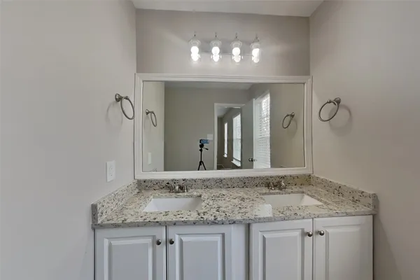 a bathroom with a granite countertop sink and a large mirror