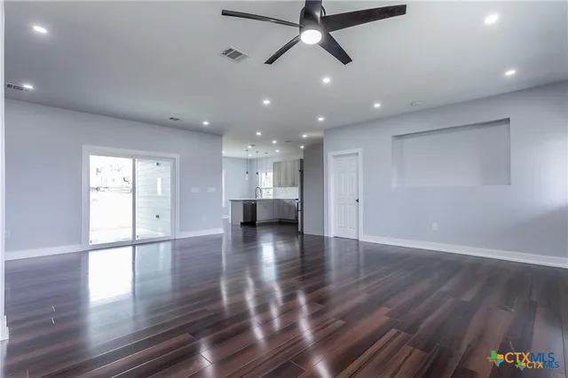 a view of an empty room with wooden floor