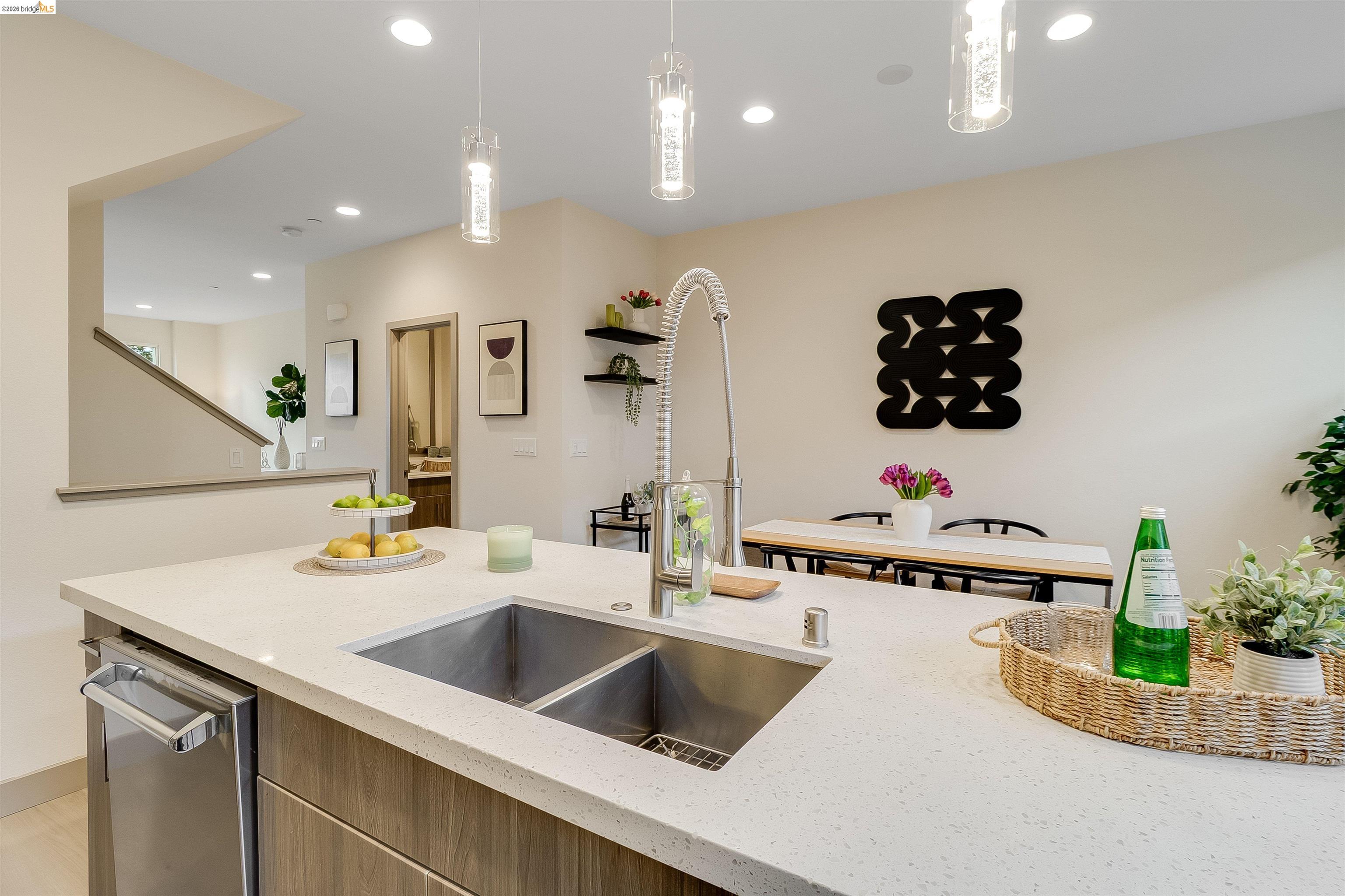 1357 Pullman Way Oakland, CA 94607 - Photo 13 of 37 Modern kitchen island featuring a double-basin stainless steel sink, a stainless steel dishwasher, and a light-toned countertop