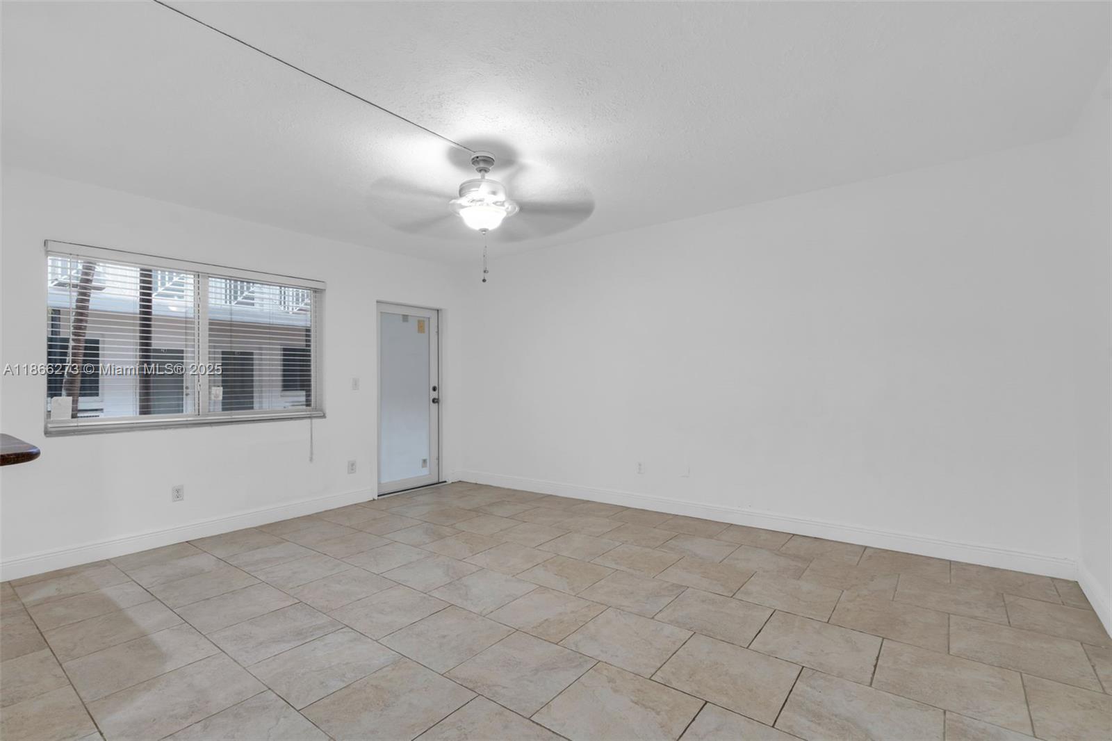 7424 Byron Avenue, Unit 2B Miami Beach, FL 33141 - Photo 4 of 25 an empty room with chandelier fan