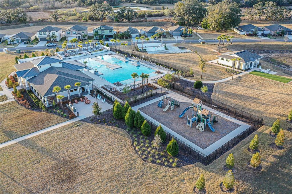 7014 Ripple Pond Loop Zephyrhills, FL 33541 - Photo 30 of 40 an aerial view of a house with a garden and lake view