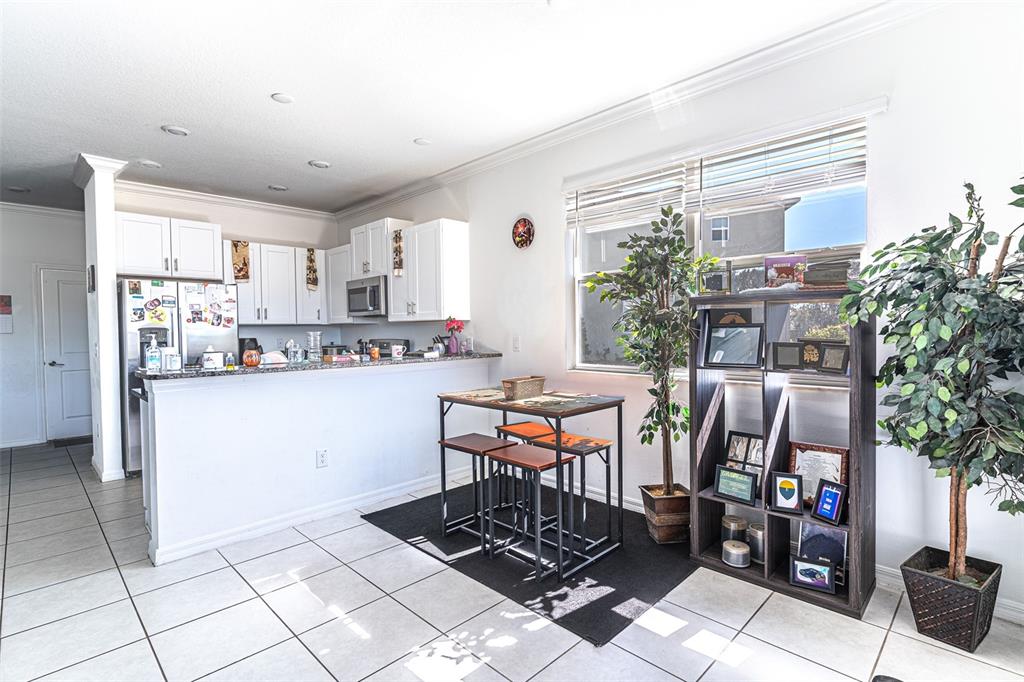 7014 Ripple Pond Loop Zephyrhills, FL 33541 - Photo 4 of 40 a kitchen with stainless steel appliances a table and chairs in it