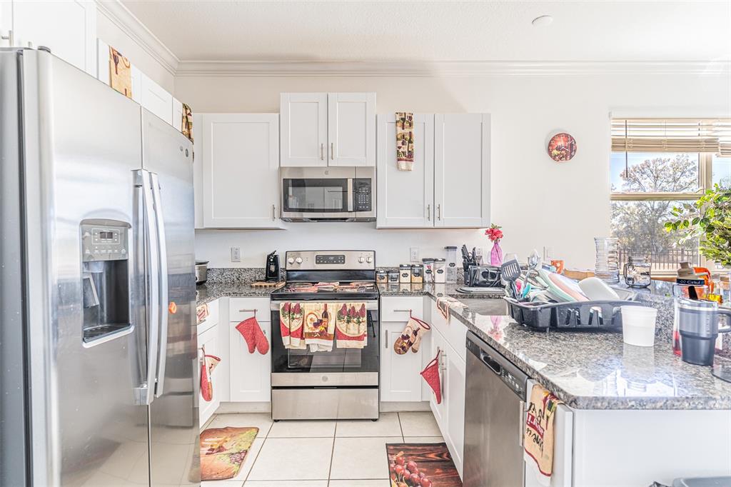 7014 Ripple Pond Loop Zephyrhills, FL 33541 - Photo 5 of 40 a kitchen with stainless steel appliances granite countertop a stove a sink and a refrigerator