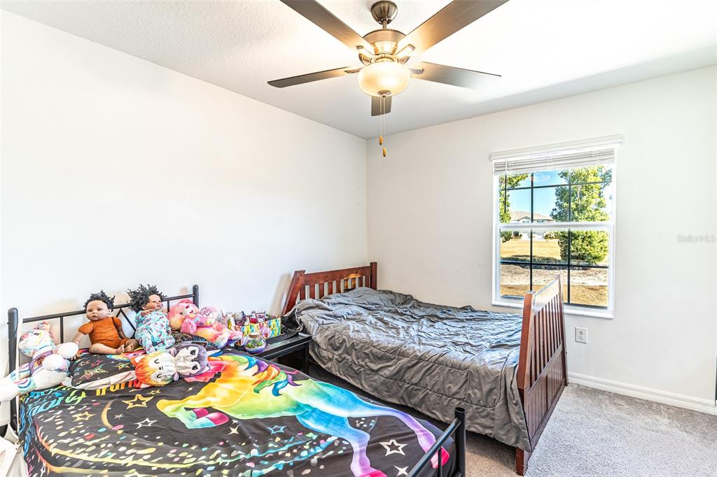 7014 Ripple Pond Loop Zephyrhills, FL 33541 - Photo 8 of 40 a bedroom with a bed and a chandelier