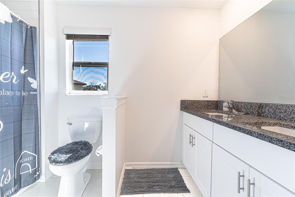 7014 Ripple Pond Loop Zephyrhills, FL 33541 - Photo 9 of 40 a bathroom with a granite countertop sink and a mirror