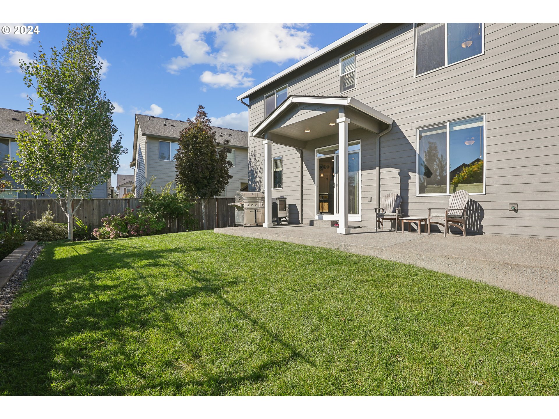 3520 Northeast Spruce Drive Camas, WA 98607 - Photo 33 of 38 a view of a white house with a yard patio and fire pit