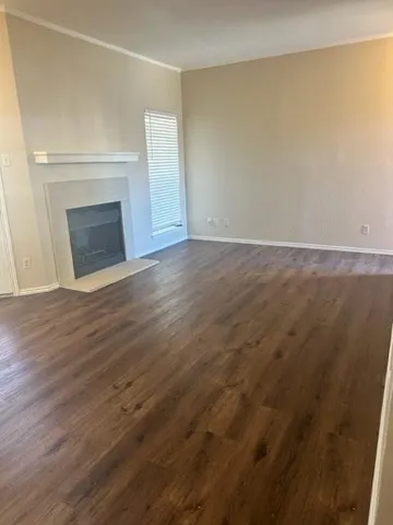 a view of empty room with wooden floor and fireplace