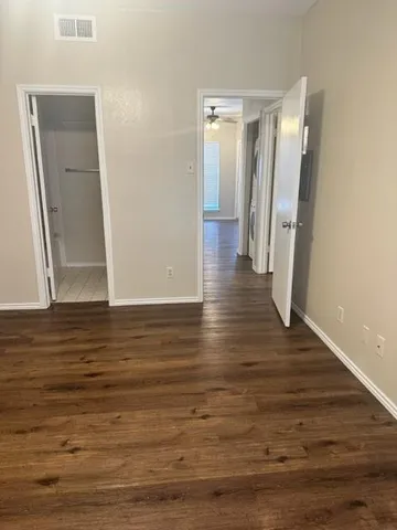 a view of empty room with wooden floor