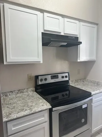 a kitchen with granite countertop cabinets stainless steel appliances and a counter space
