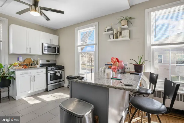 a kitchen with a dining table chairs cabinets and appliances