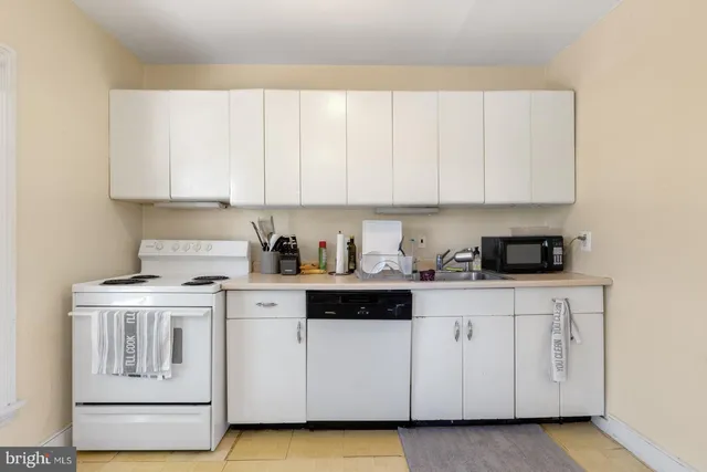 a kitchen with white cabinets and white appliances