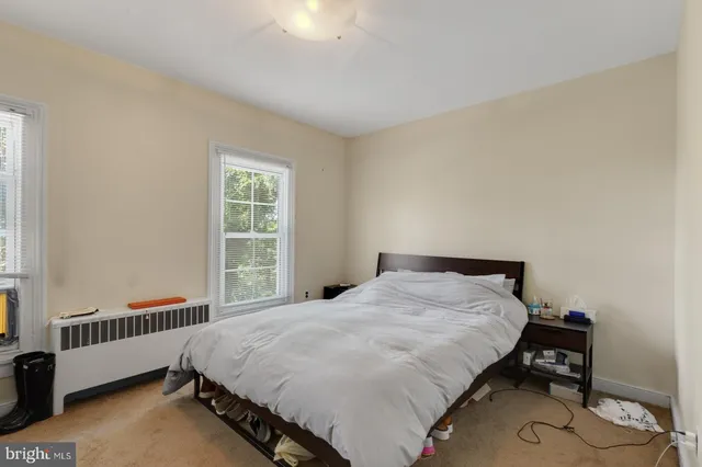 a bed sitting in a bedroom next to a window
