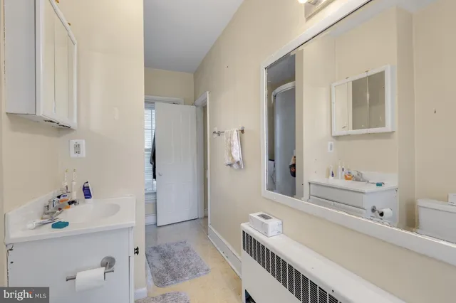 a bathroom with a sink a tub and a mirror