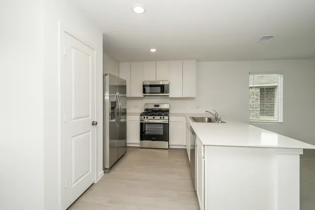 a kitchen with stainless steel appliances a refrigerator stove and microwave