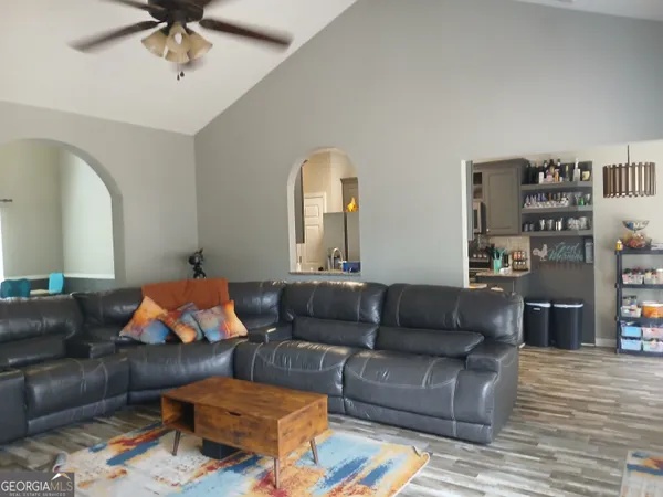 a living room with furniture and a wooden floor