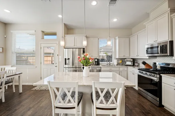 a large kitchen with a table and chairs