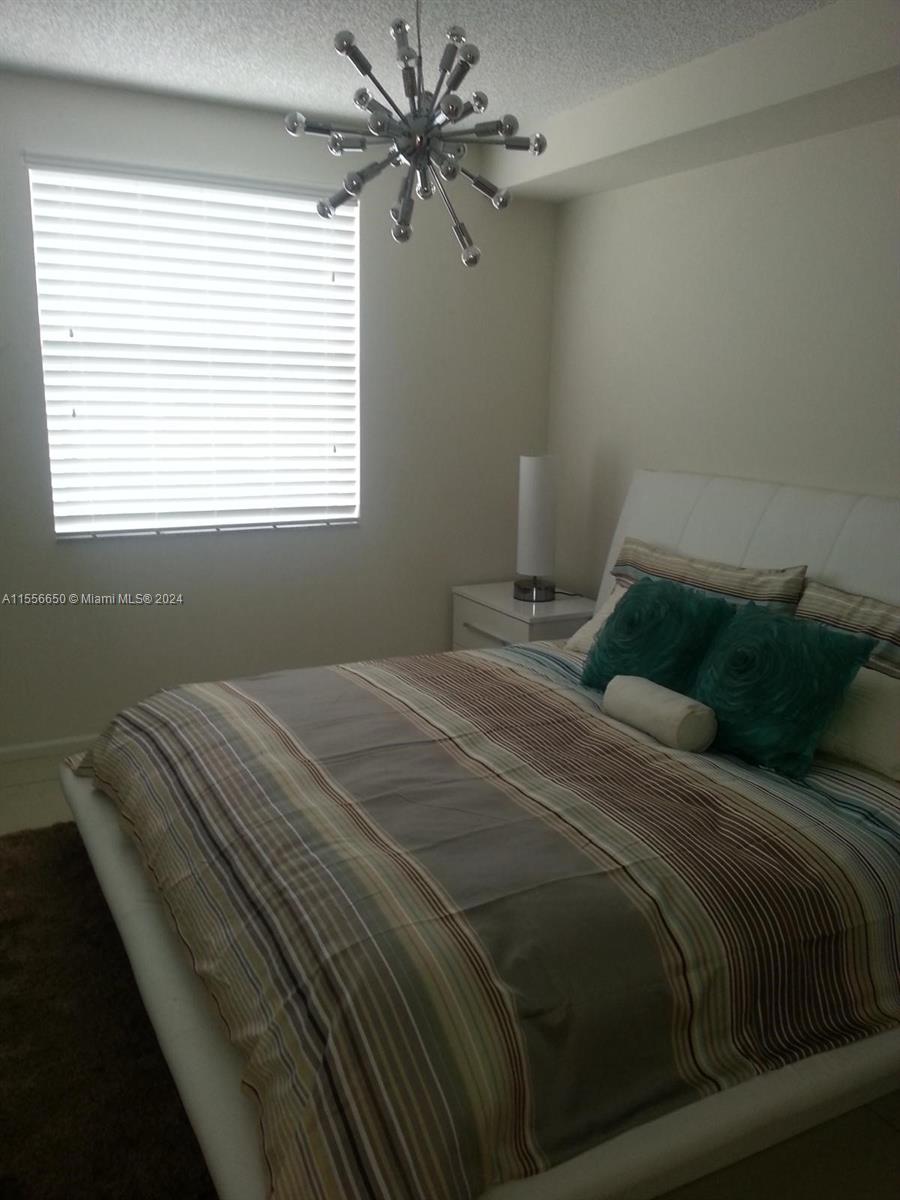 17100 North Bay Road, Unit 1402 Sunny Isles Beach, FL 33160 - Photo 11 of 25 a bedroom with a bed and a window