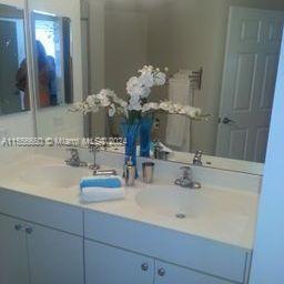 17100 North Bay Road, Unit 1402 Sunny Isles Beach, FL 33160 - Photo 12 of 25 a bathroom with a sink vanity and a mirror