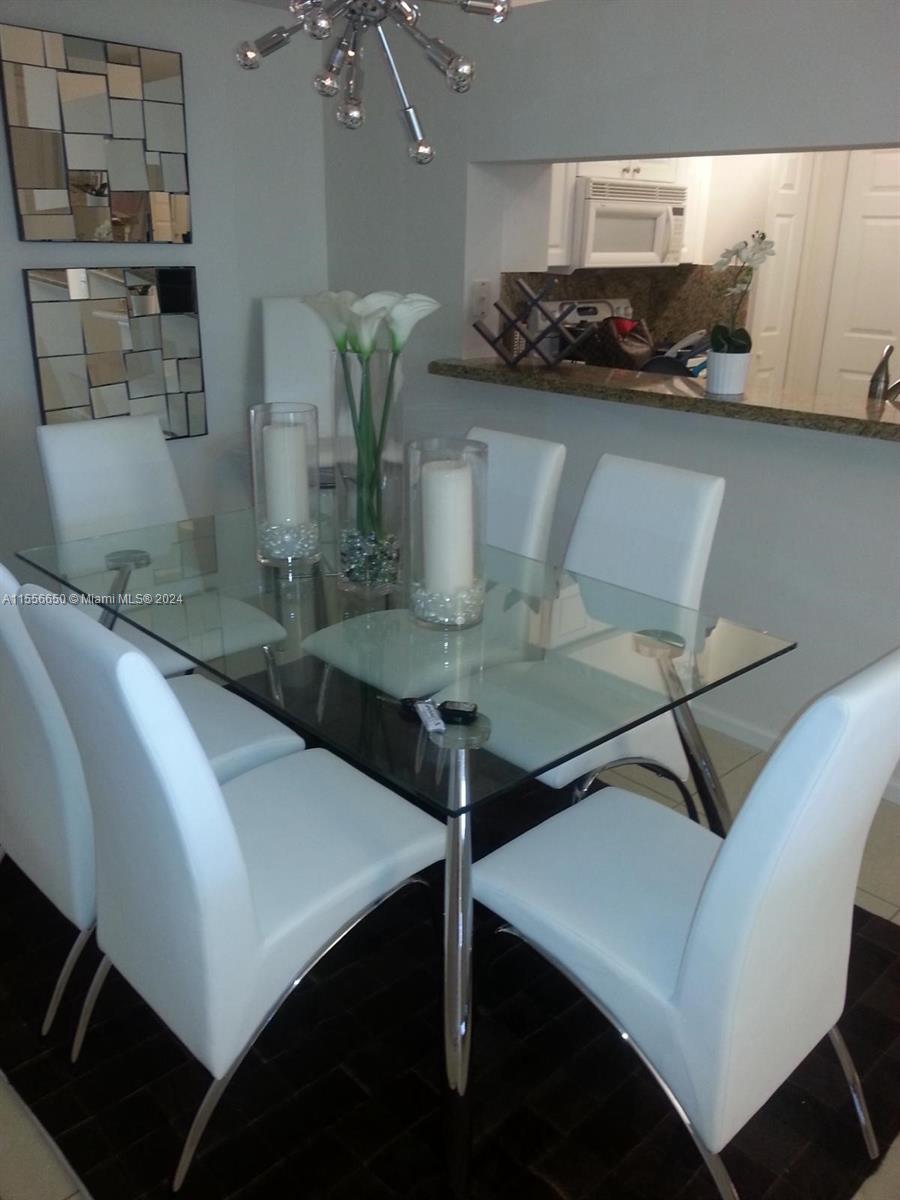 17100 North Bay Road, Unit 1402 Sunny Isles Beach, FL 33160 - Photo 8 of 25 a kitchen with a table chairs and a stove