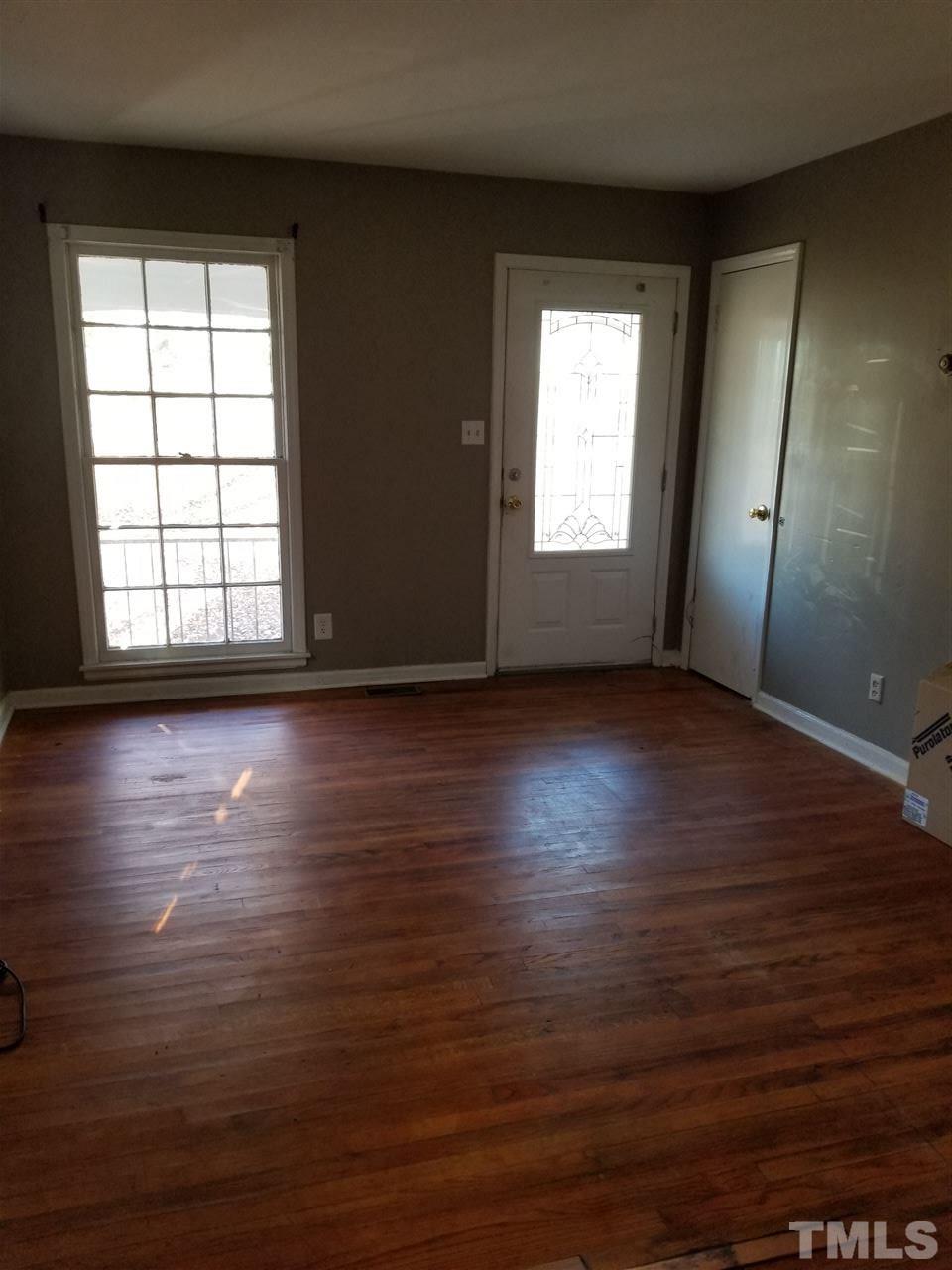 1306 Lenoir Street Raleigh, NC 27610 - Photo 1 of 7 an empty room with wooden floor and windows