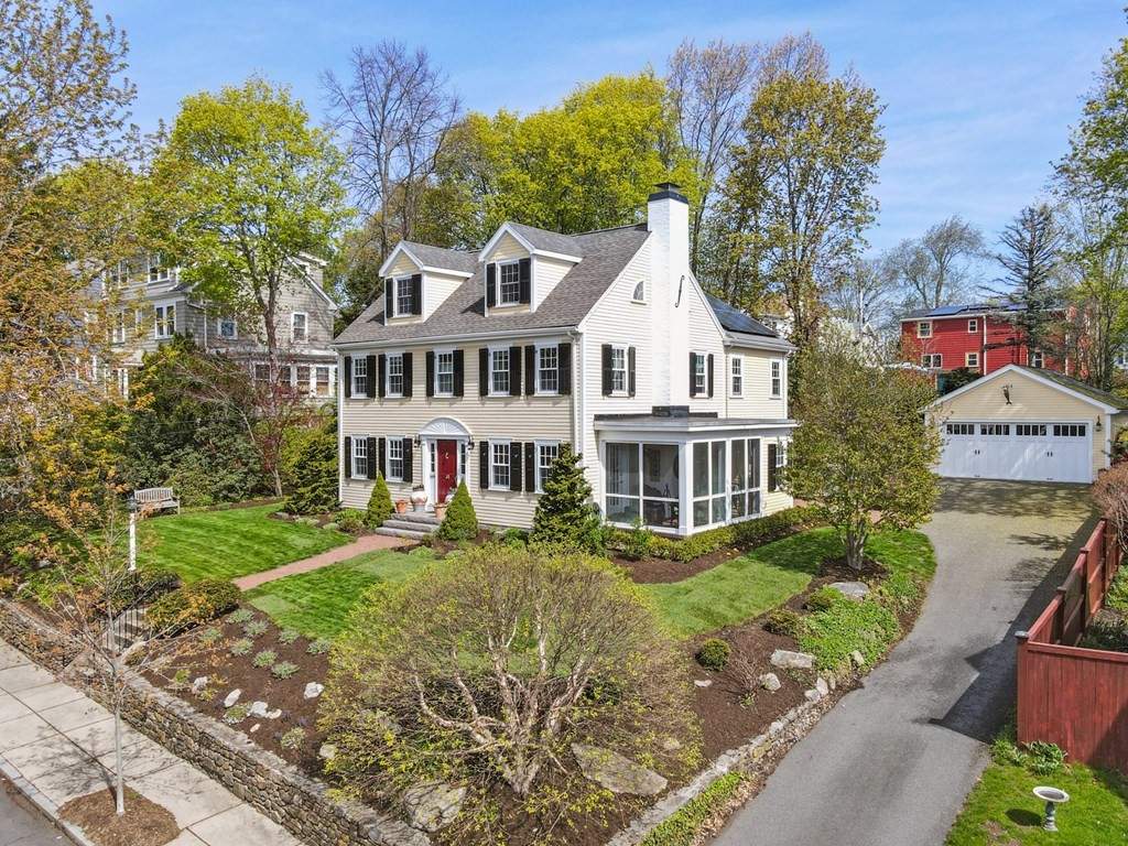 a front view of a house with a garden and trees