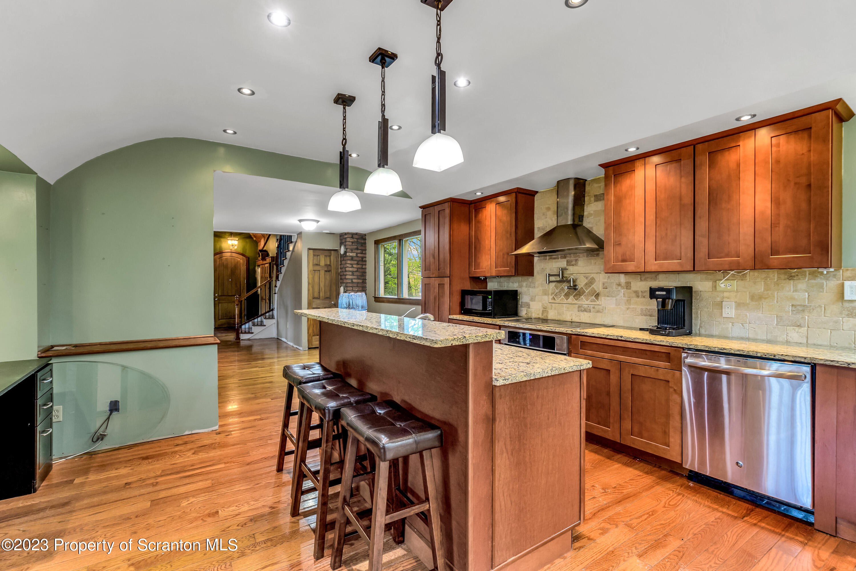 21 Ridge Street Dallas, PA 18612 - Photo 55 of 92 a open kitchen with stainless steel appliances granite countertop a sink a stove and a wooden floors