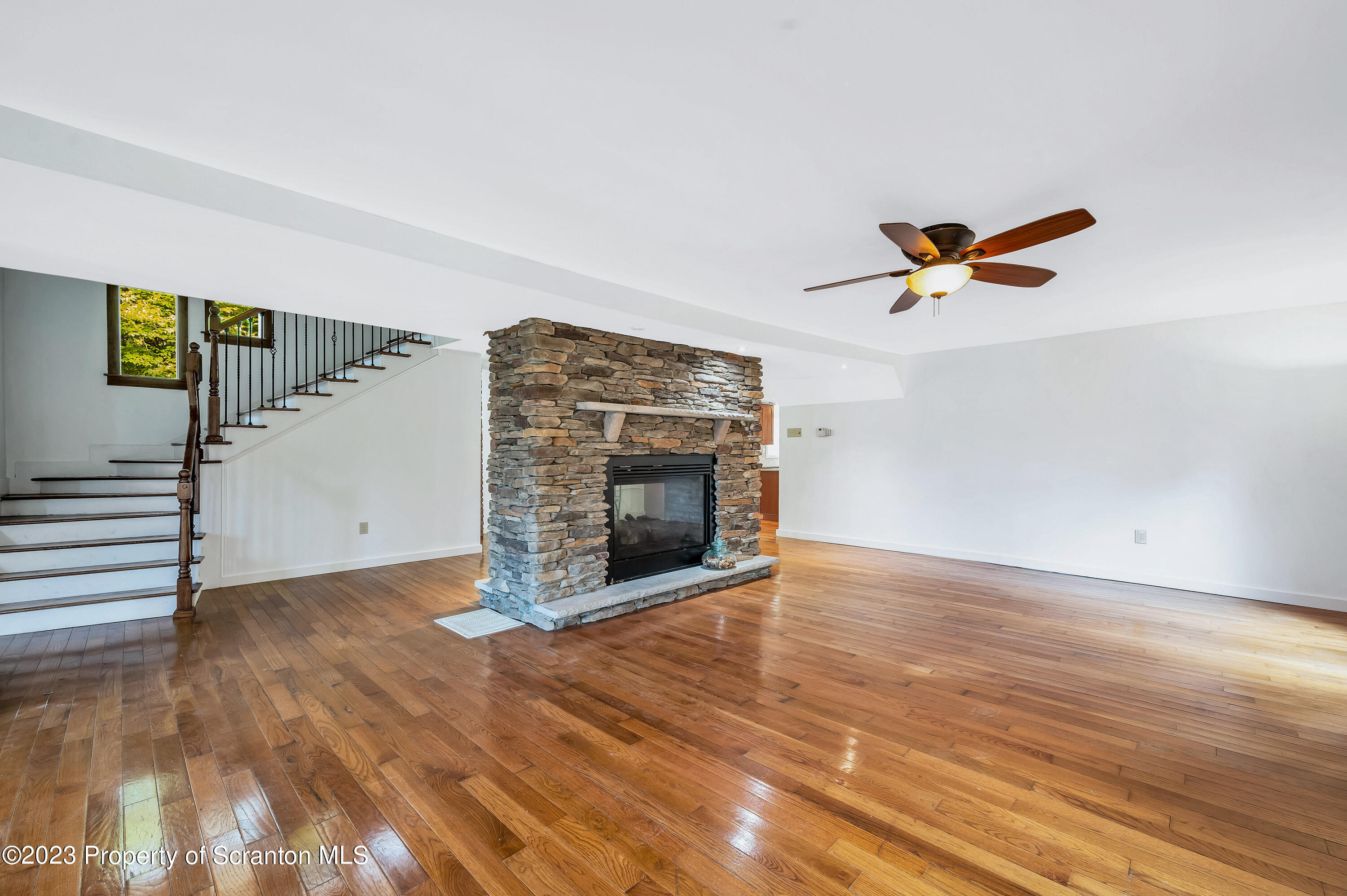 21 Ridge Street Dallas, PA 18612 - Photo 7 of 92 a view of a livingroom with wooden floor a ceiling fan and fireplace
