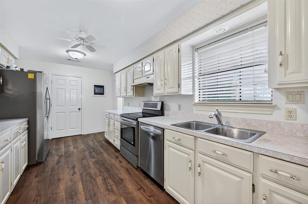443 Lakewood Road Denison, TX 75020 - Photo 14 of 38 a kitchen with cabinets a sink and stainless steel appliances