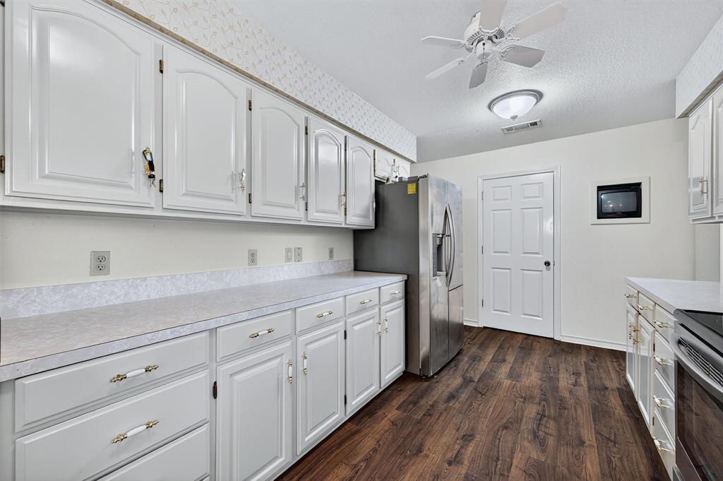 443 Lakewood Road Denison, TX 75020 - Photo 15 of 38 a kitchen with sink cabinets and wooden floor