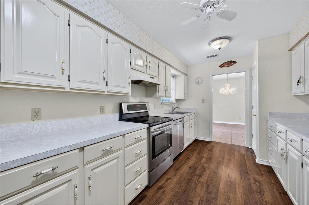 443 Lakewood Road Denison, TX 75020 - Photo 16 of 38 a kitchen with granite countertop white cabinets and white appliances