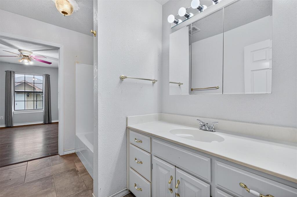 443 Lakewood Road Denison, TX 75020 - Photo 21 of 38 a bathroom with a sink vanity and a mirror