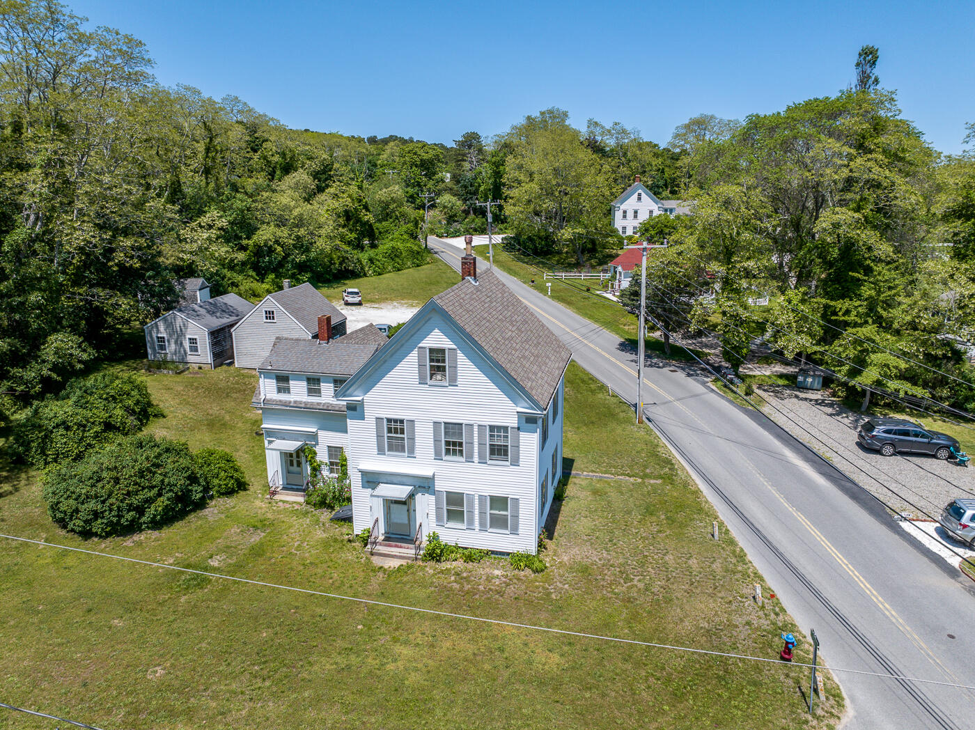 105 West Main Street Wellfleet, MA 02667 - Photo 10 of 59 a view of a white house with a big yard and potted plants