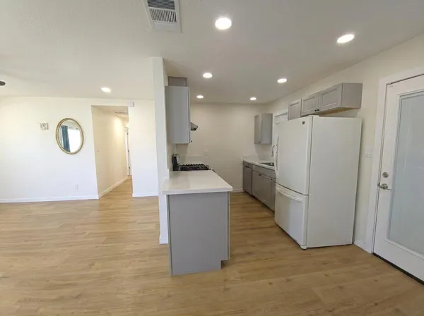 a view of kitchen with refrigerator cabinets and wooden floor