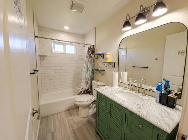 a bathroom with a granite countertop sink toilet and shower