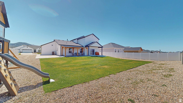 1127 4240 North Enoch, UT 84721 - Photo 51 of 56 View of back of house featuring a playground, a patio, a fenced backyard, and a residential view