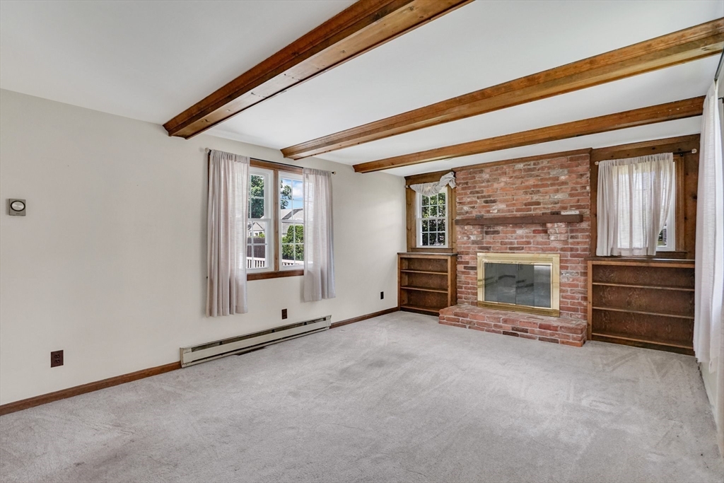 27 Oregon Street Springfield, MA 01118 - Photo 19 of 42 a view of an empty room with a fireplace and a window