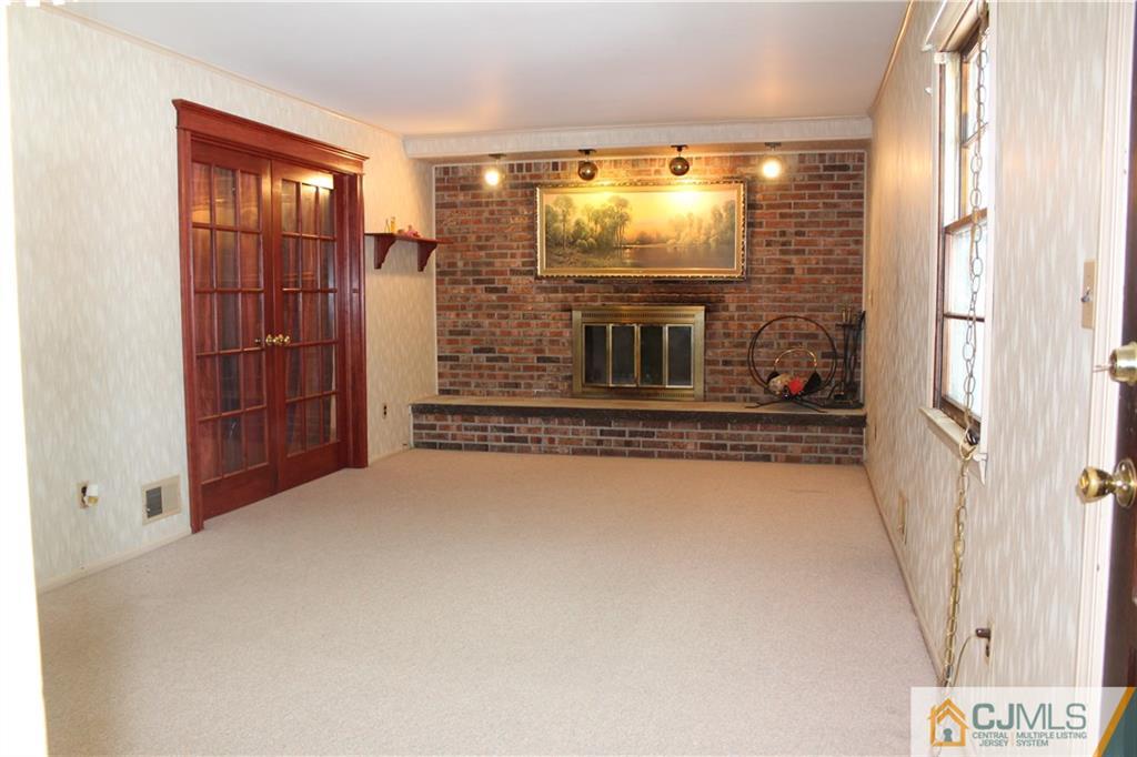 23 Hilltop Road Edison, NJ 08820 - Photo 13 of 17 a view of an empty room with a fireplace and a window