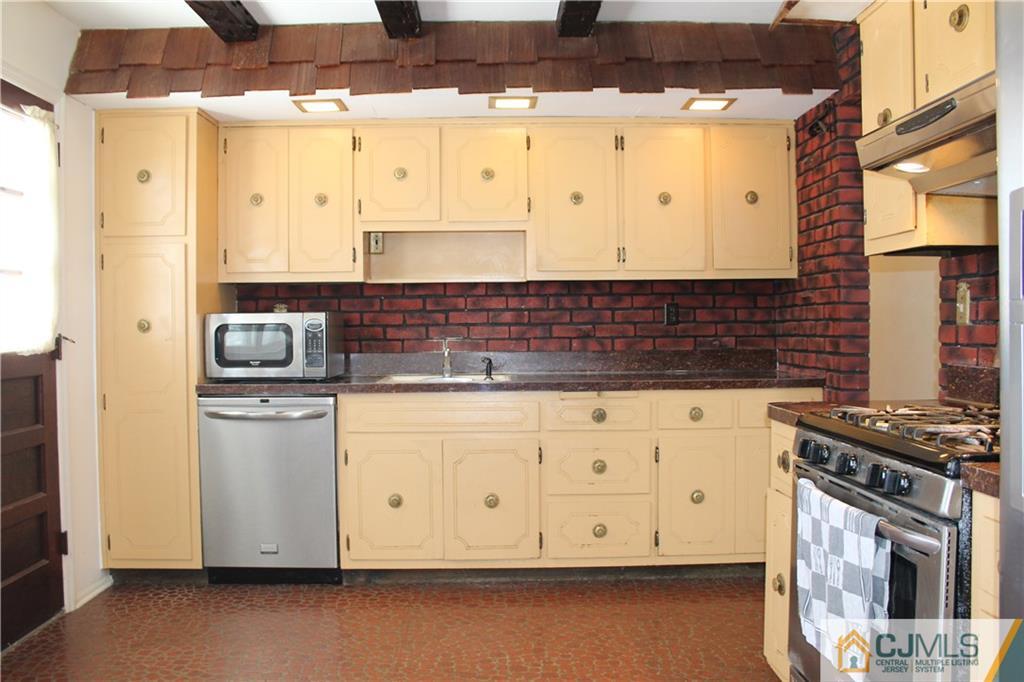 23 Hilltop Road Edison, NJ 08820 - Photo 6 of 17 a kitchen with stainless steel appliances a stove a sink a refrigerator and cabinets