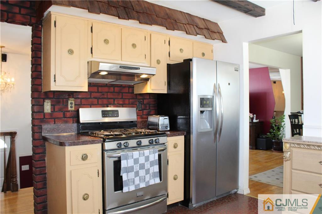 23 Hilltop Road Edison, NJ 08820 - Photo 7 of 17 a kitchen with stainless steel appliances granite countertop a refrigerator a stove and a sink with wooden floor