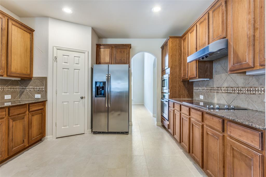 1104 Carson Drive Allen, TX 75002 - Photo 15 of 36 a kitchen with stainless steel appliances granite countertop a refrigerator a sink dishwasher a oven with white cabinets and wooden floor