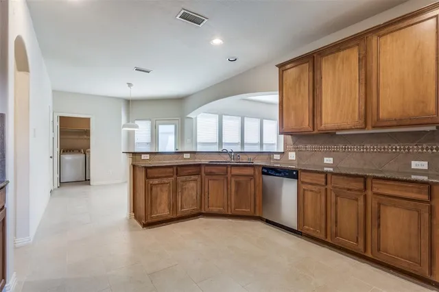 a kitchen with granite countertop a stove a sink and a microwave