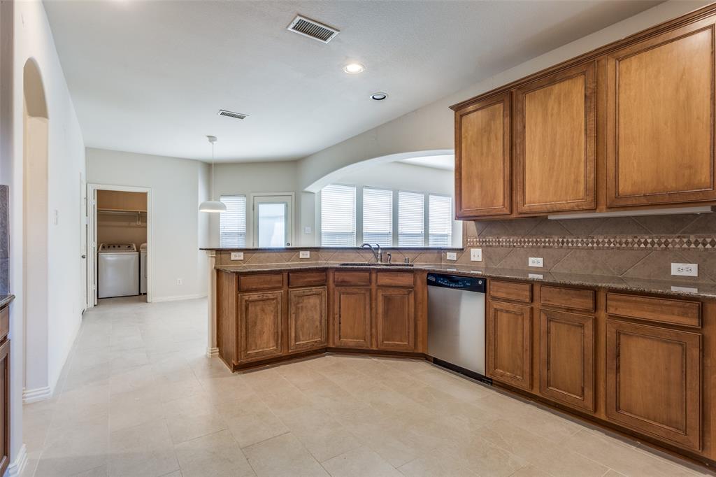 1104 Carson Drive Allen, TX 75002 - Photo 16 of 36 a kitchen with granite countertop a stove a sink and a microwave
