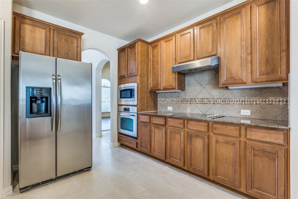 1104 Carson Drive Allen, TX 75002 - Photo 17 of 36 a kitchen with stainless steel appliances granite countertop a refrigerator and a sink